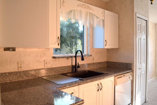 kitchen with white dishwasher, light tile patterned flooring, white cabinetry, and sink