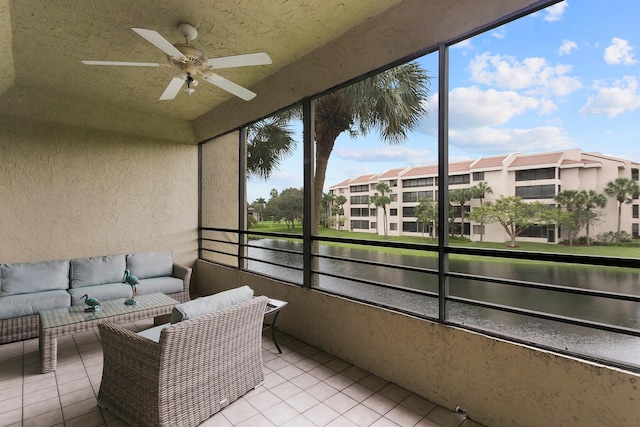 sunroom / solarium with ceiling fan and a water view