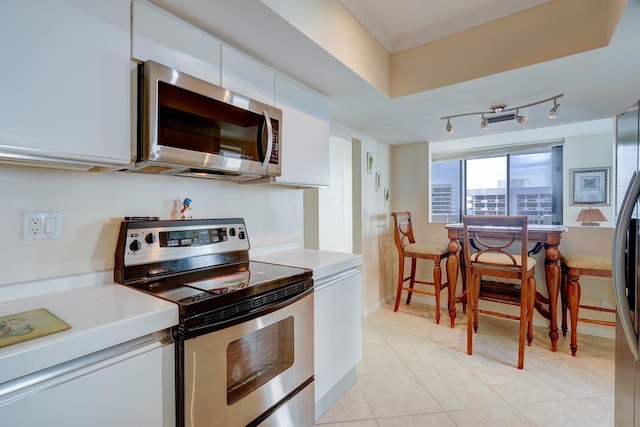 kitchen featuring appliances with stainless steel finishes, rail lighting, white cabinetry, and light tile patterned flooring