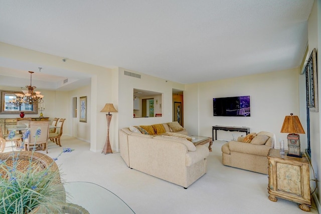 carpeted living room with an inviting chandelier