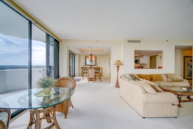 carpeted living room with a water view and a chandelier