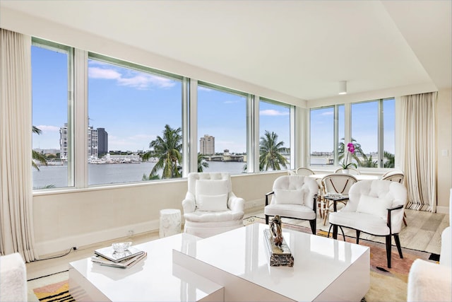 living room with a wealth of natural light, light hardwood / wood-style floors, and a water view