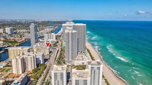 birds eye view of property with a water view and a beach view