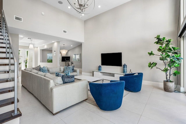 living room featuring a towering ceiling, a notable chandelier, and light tile patterned flooring