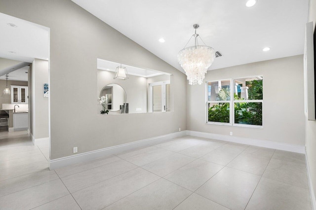 tiled empty room with a chandelier, sink, and vaulted ceiling