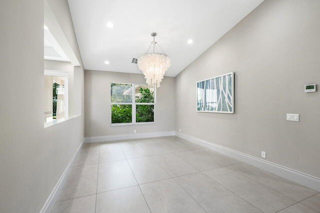 tiled spare room featuring vaulted ceiling and a notable chandelier