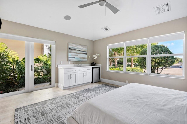 bedroom with multiple windows, light wood-type flooring, access to outside, and ceiling fan