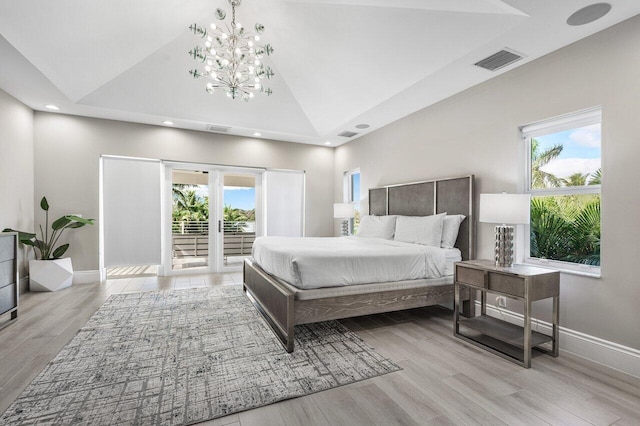 bedroom with french doors, access to outside, an inviting chandelier, high vaulted ceiling, and light hardwood / wood-style floors