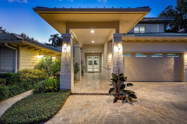 exterior entry at dusk with french doors and a garage