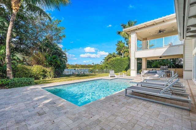 view of pool featuring a patio area, ceiling fan, and exterior kitchen