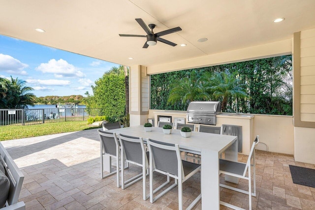 view of patio / terrace featuring grilling area, ceiling fan, and a water view