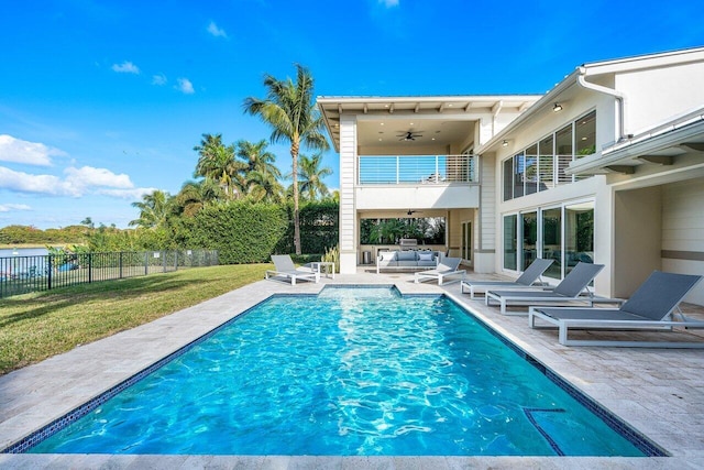 view of pool featuring ceiling fan, an outdoor living space, a patio, and a yard