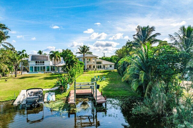 back of property with a balcony, ceiling fan, a patio area, a fenced in pool, and a lawn