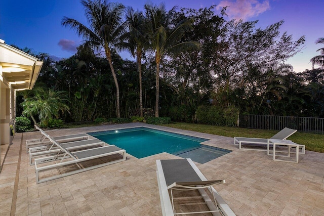 pool at dusk featuring a patio area