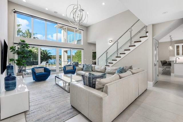 living room featuring a chandelier, light tile patterned floors, sink, and a high ceiling