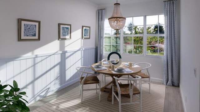 dining space featuring a notable chandelier, crown molding, and light hardwood / wood-style flooring