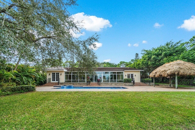 rear view of property featuring a gazebo, a patio area, a yard, and french doors