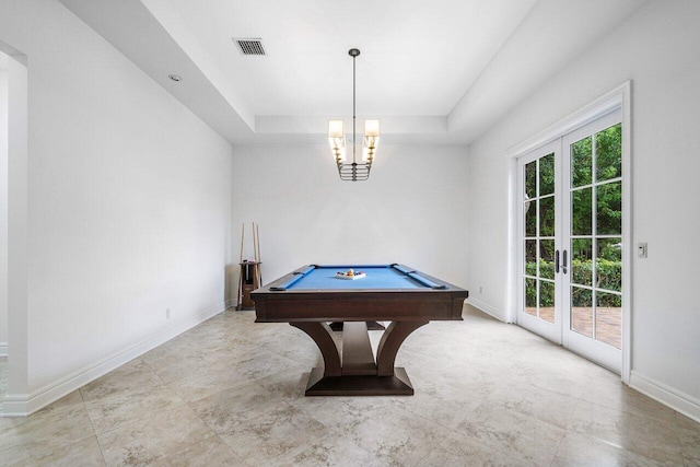 recreation room featuring a tray ceiling, billiards, a notable chandelier, and french doors