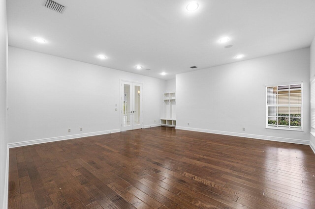 unfurnished living room featuring dark hardwood / wood-style floors and french doors