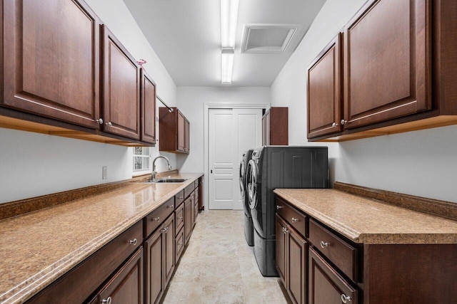 washroom with sink, washer and dryer, and cabinets