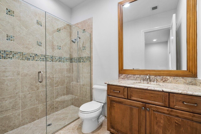 bathroom featuring a shower with shower door, toilet, and vanity