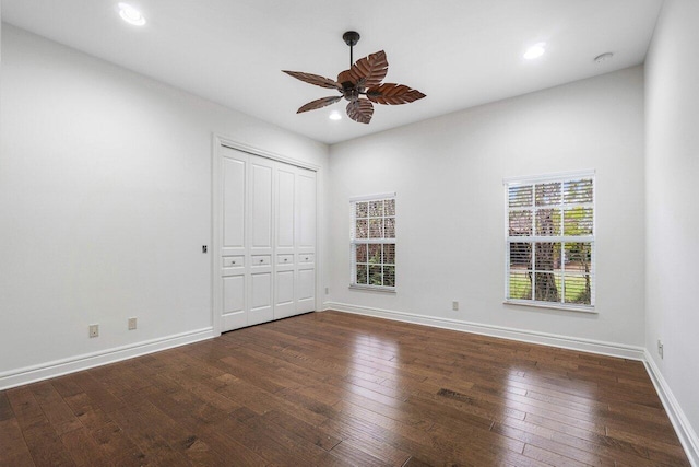 unfurnished bedroom featuring dark wood-type flooring, ceiling fan, and a closet