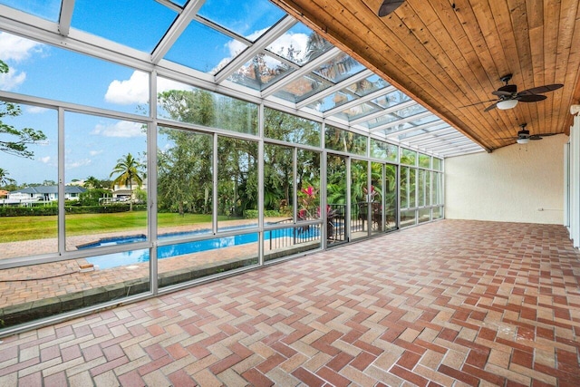 unfurnished sunroom with ceiling fan and wooden ceiling