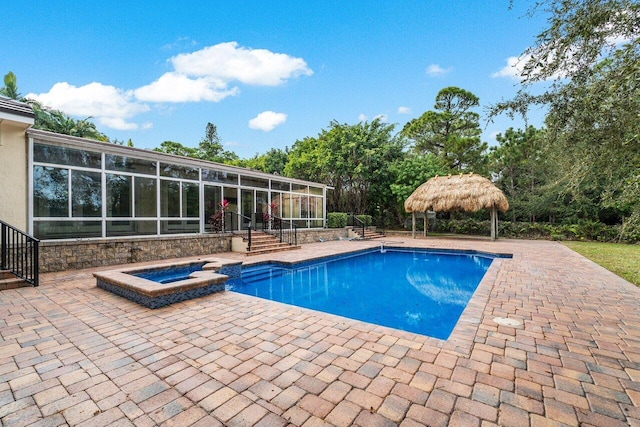 view of swimming pool featuring a patio area, a sunroom, and an in ground hot tub