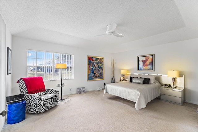 bedroom with ceiling fan, carpet floors, and a textured ceiling