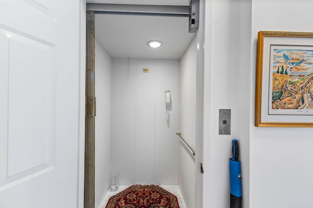 bathroom featuring elevator and tile patterned flooring