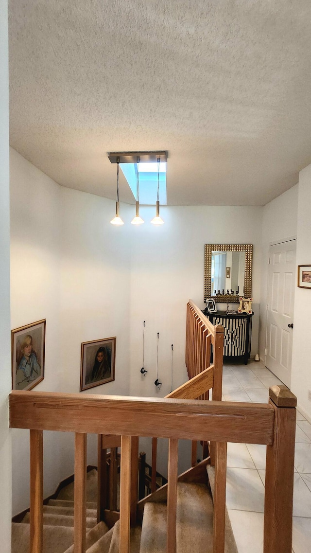 staircase featuring tile patterned flooring and a textured ceiling