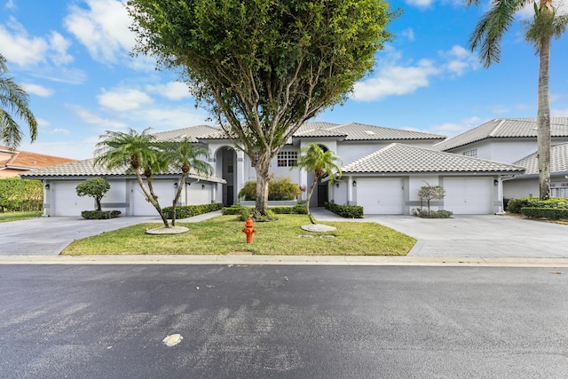 mediterranean / spanish-style home featuring a garage and a front lawn