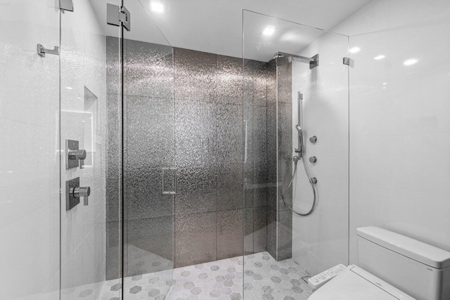 bathroom with tile patterned floors, an enclosed shower, and toilet