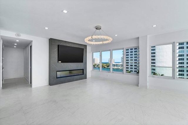 unfurnished living room with a premium fireplace and an inviting chandelier