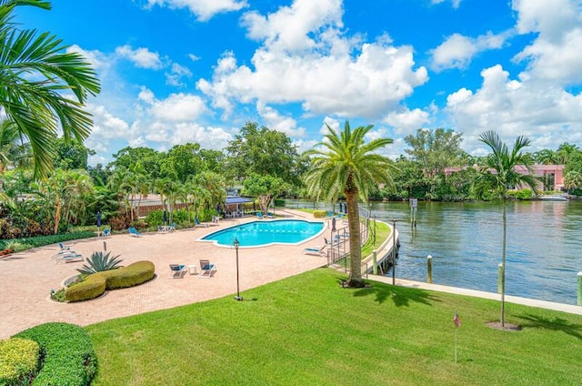 view of pool with a patio area, a yard, and a water view