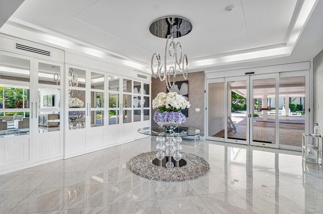 interior space with french doors and a raised ceiling