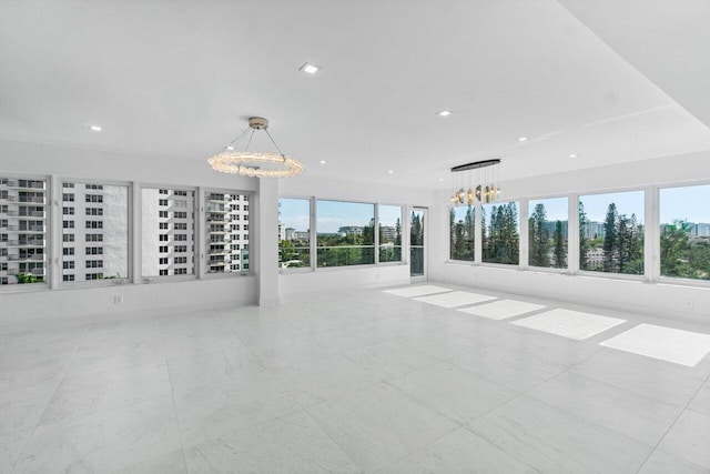 unfurnished room with an inviting chandelier