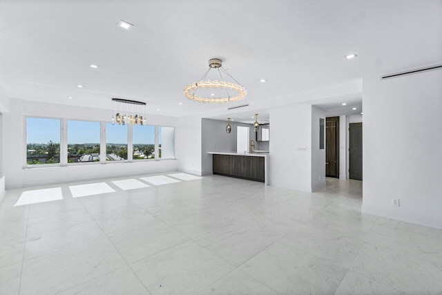 unfurnished living room with sink and an inviting chandelier