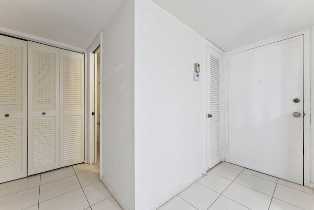 hall with light tile patterned floors and a textured ceiling