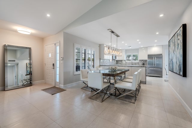 kitchen with white cabinets, hanging light fixtures, decorative backsplash, kitchen peninsula, and stainless steel appliances