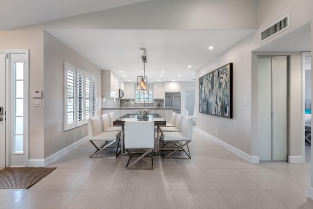 dining space with light tile patterned floors and lofted ceiling