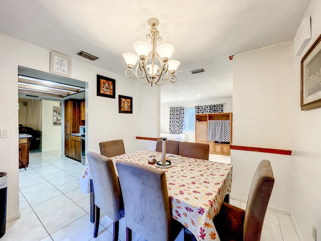 dining space featuring light tile patterned floors, a textured ceiling, and an inviting chandelier