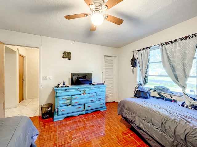 bedroom with ceiling fan, a textured ceiling, and a closet