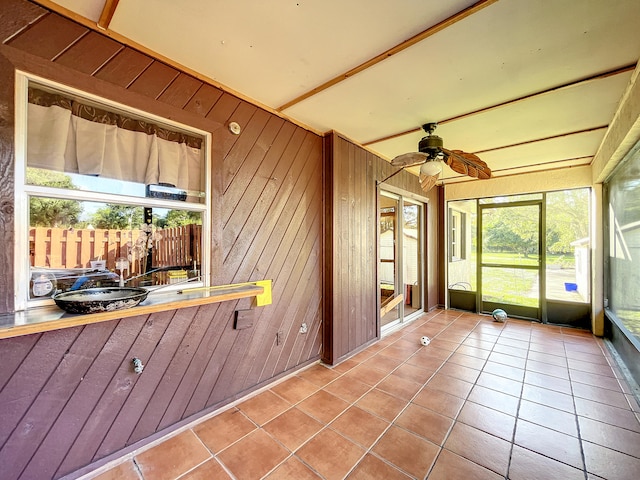 unfurnished sunroom featuring ceiling fan