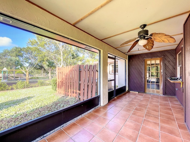 unfurnished sunroom featuring ceiling fan