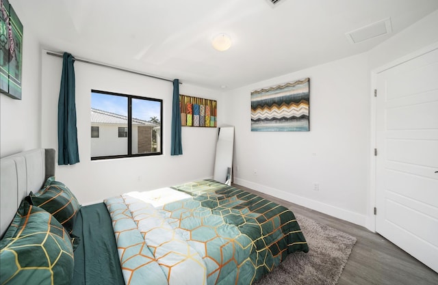 bedroom with dark hardwood / wood-style floors