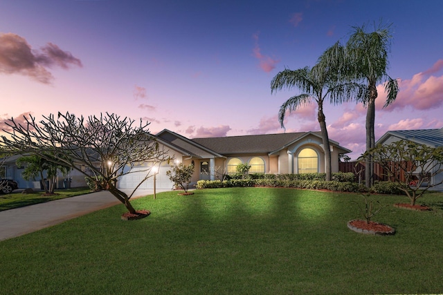 ranch-style house featuring a yard and a garage