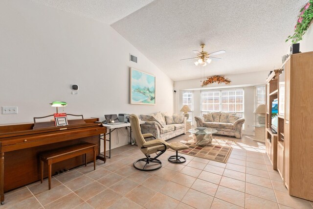 living room featuring a textured ceiling, ceiling fan, light tile patterned floors, and lofted ceiling