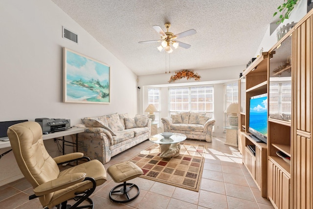 living room featuring ceiling fan, lofted ceiling, a textured ceiling, and light tile patterned floors