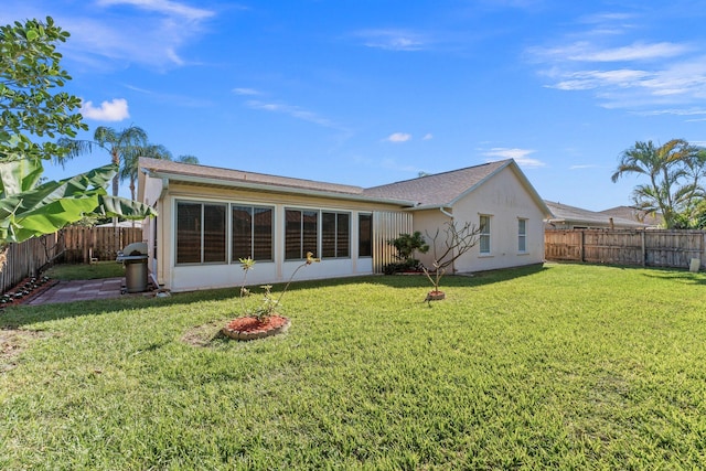 rear view of house featuring a lawn